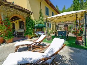 une terrasse avec des chaises longues et un parasol dans l'établissement Holiday Home Il Farinaio by Interhome, à Cortone