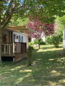 une petite maison dans une cour avec un arbre dans l'établissement Camping Calme et Nature, à Castellane