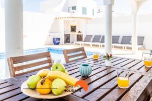 a wooden table with a plate of fruit on it at #072 Casa Longa by Home Holidays in Albufeira