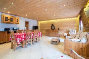 a living room with a table and chairs and a kitchen at Appartement les murailles in Morzine
