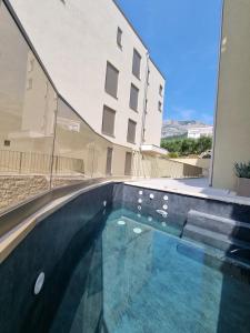 a swimming pool in front of a building at Marina Bay - Exclusive Apartment with Private Pool and Adriatic Sea View in Tučepi