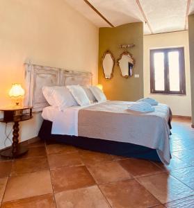 1 dormitorio con 1 cama grande y 2 espejos en la pared en Madama Langa Country House con piscina nelle vigne, en Montelupo Albese
