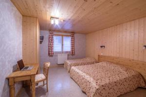 a bedroom with two beds and a desk with a laptop at Rare Chalet 30 Personnes in Morzine