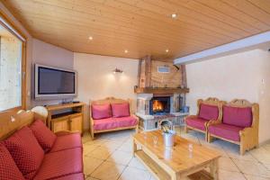 a living room with two red chairs and a fireplace at Rare Chalet 30 Personnes in Morzine