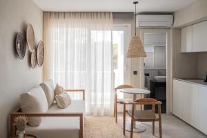 sala de estar con sofá y sillas y cocina en Boho Suites Formentera, en Es Pujols
