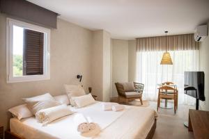 a bedroom with a large white bed and a table at Boho Suites Formentera in Es Pujols