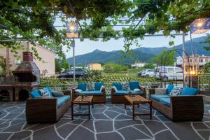 a patio with couches and a fireplace with mountains in the background at Studios Liolios #5 in Skala Potamias