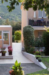 un edificio con balcón con plantas y flores en Villa Pari Apartment en Kotor