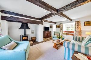 ein Wohnzimmer mit 2 blauen Sofas und einem Kamin in der Unterkunft Lower Farm Cottage in Stourton Caundle