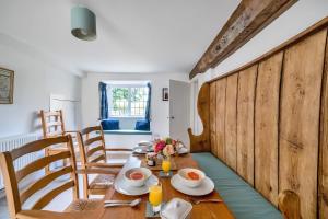 ein Esszimmer mit einem Holztisch und Stühlen in der Unterkunft Lower Farm Cottage in Stourton Caundle