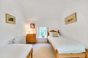 a bedroom with two beds and a window at Lower Farm Cottage 