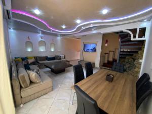 a living room with a table and a couch and a dining room at Beau Duplex à Imi ouaddar in Agadir nʼ Aït Sa
