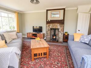 a living room with a couch and a fireplace at Melbecks in Abergele