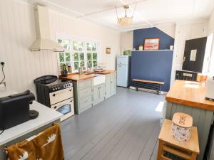 uma cozinha com electrodomésticos brancos e paredes azuis em Melbecks em Abergele