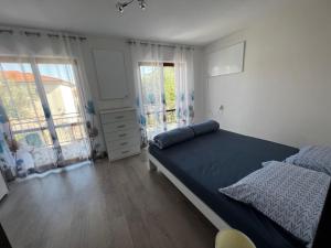 1 dormitorio con 1 cama grande y 2 ventanas en Danilo's Appartments, en Koper