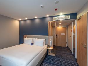 una camera d'albergo con letto e corridoio di Holiday Inn Express - Hamburg South A7-AS42, an IHG Hotel a Egestorf