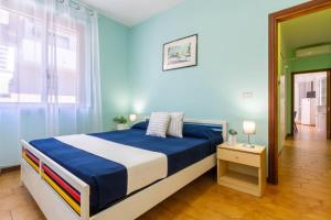 - une chambre bleue avec un lit et une fenêtre dans l'établissement Appartamento La Pinetina Trilo PT - MyHo Casa, à Tortoreto Lido