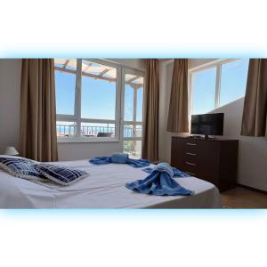 Schlafzimmer mit einem Bett und einem blauen Bademantel in der Unterkunft Avrora Studio's in Byala