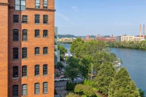 a building next to a river next to a building at 2BR 2BA Lux Historic Loft With Pool in Pittsburgh