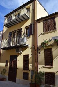 ein gelbes Gebäude mit einem Balkon an der Seite in der Unterkunft Casa Vacanze del Golfo in Castellammare del Golfo