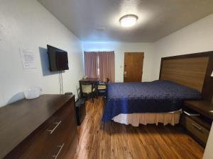 a hotel room with a bed and a desk at Sunrise Motor Inn in Cody
