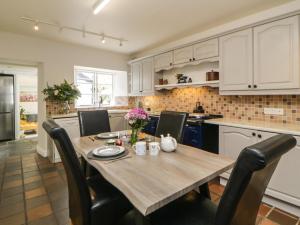 a kitchen with a wooden table and black chairs at Lower Culvermead in Tavistock