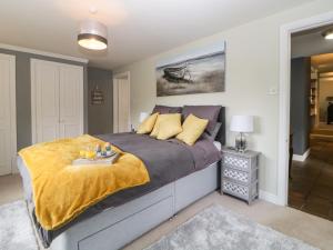 a bedroom with a large bed with a yellow blanket on it at Lower Culvermead in Tavistock