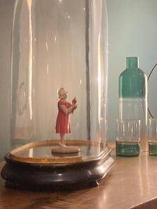 una pequeña estatuilla de una mujer parada en un frasco de cristal en le secret du chat, en Cordes-sur-Ciel