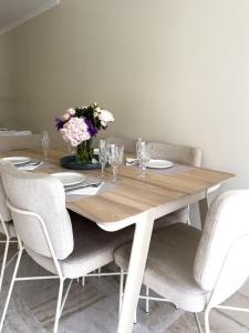 Cosy stay - LA CROISETTE في كان: طاولة خشبية مع كراسي و إناء من الزهور