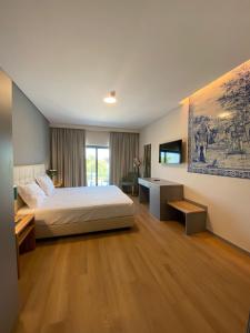 een hotelkamer met een bed en een televisie bij Villa Rey Spa & Hotel in Vila de Rei