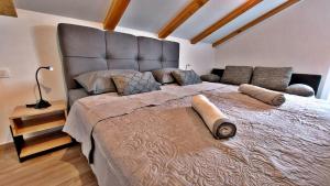 un grande letto con una grande testiera in una camera da letto di Vinodol Apartments 1 and 2 a Križišće