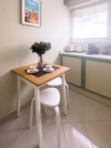 a kitchen with a wooden table and two chairs at Cosy stay - LA CROISETTE in Cannes