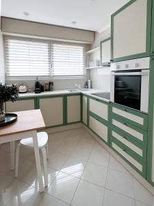 uma cozinha com armários verdes e brancos e uma mesa em Cosy stay - LA CROISETTE em Cannes