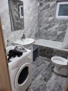 La salle de bains est pourvue d'un lave-linge et d'un lavabo. dans l'établissement Apartman 4M, à Foča