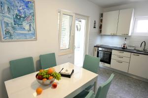 - une cuisine avec une table et un bol de fruits dans l'établissement House La Vista Hvar, à Hvar