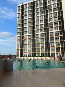 a large building with people swimming in a swimming pool at Valley Suites by WyattHomes in Kuantan