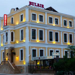 - un grand bâtiment blanc avec un panneau dans l'établissement Семеен Хотел "Булаир", à Bourgas