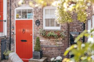 a brick house with a red door and windows at Ironbridge View Townhouse - Stunning view of the Iron Bridge UK WINNER 2024 'MOST PICTURESQUE SELF-CATERING HOLIDAY HOME' of the year' & WINNER '2024 BEST HOLIDAY HOME IN SHROPSHIRE' in Ironbridge