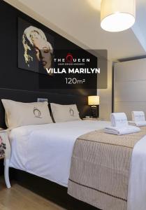 a bedroom with a large bed with a poster on the wall at The Queen Luxury Apartments - Villa Marilyn in Luxembourg