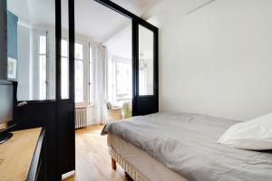 - une chambre avec un lit, un bureau et des fenêtres dans l'établissement Appartement 16th Tour Eiffel - Central Paris, à Paris