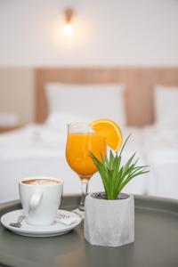 uma mesa com uma chávena de café e um copo de sumo de laranja em NACIONAL em Trebinje