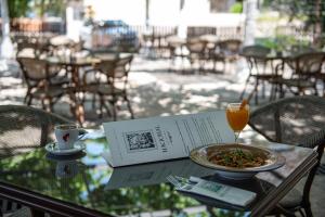 a table with a book and a plate of food and a drink at NACIONAL in Trebinje