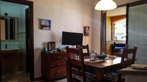 a dining room with a table and a television at Villetta Rossi in Nebida
