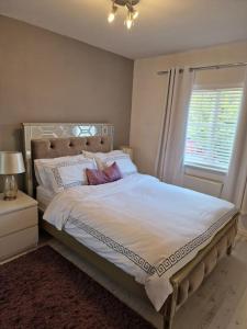 a bedroom with a large white bed with a window at Silverstone Stays in Wootton