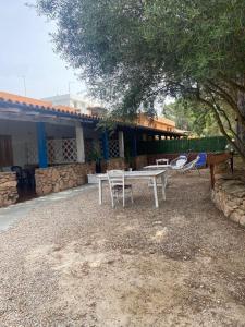 een groep witte tafels en stoelen voor een huis bij Le stanze del mare in Golfo Aranci