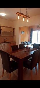 a dining room table with chairs and a kitchen at Apartment Maxim in Primošten
