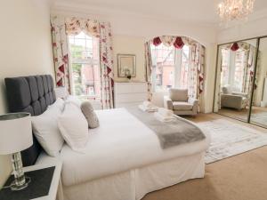 Un dormitorio con una gran cama blanca y ventanas. en 50 West Street Edelweiss, en Scarborough