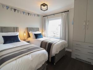 a bedroom with two beds and a window at Moelwyn 57D South Snowdon Wharf in Porthmadog