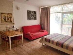 a living room with a red couch and a table at Studio with garden in Arona