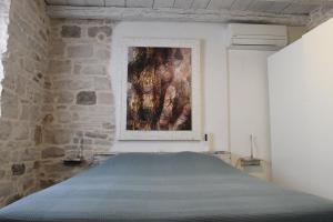 Bett in einem Zimmer mit Wandgemälde in der Unterkunft Villa Arte in Bale